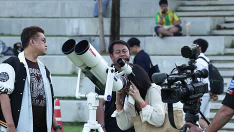 people taking turns observing through a telescope