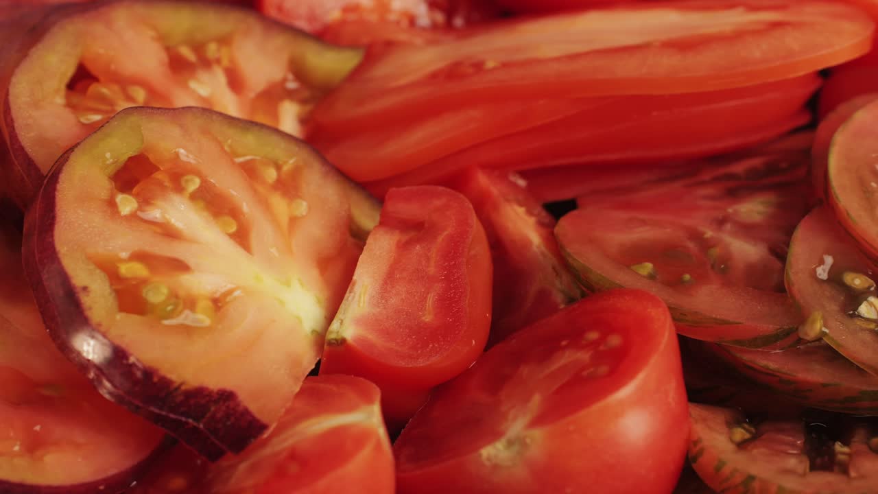 Cutting colorful organic tomatoes on wooden desk . Mix tomatoes background, Several varieties of sliced tomatoes top view. Different assorted colorful tomatoes, heirloom, cherry, rose, beefsteak, cocktail, grape, purple.