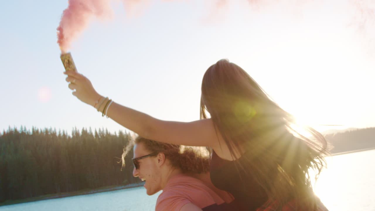 las parejas viajan a espaldas con humo rosado.