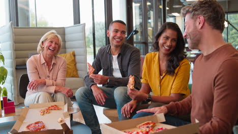 personal en una reunión informal en la oficina con pizza para llevar después del trabajo
