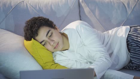 boy lying on sofa at home relaxing and daydreaming.