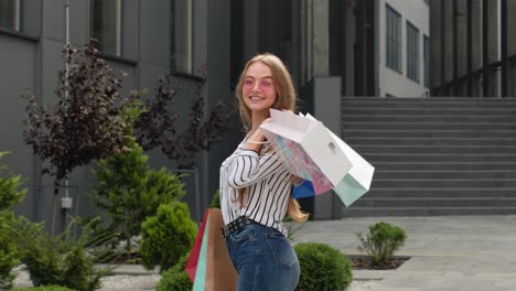 student girl walking with shopping bags. black friday holiday sale discounts, low price purchases