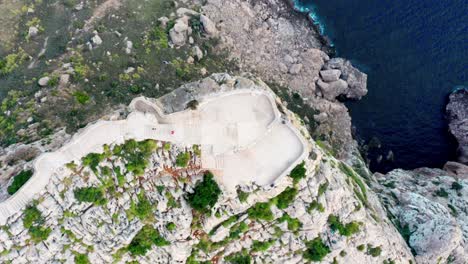 Vista-Aérea-Del-Océano-Iluminado-Por-El-Sol-En-Un-Paisaje-Exterior-Vacío-Con-Plataforma-De-Observación-En-La-Cima-De-La-Montaña