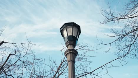 Umlaufende-Aufnahme-Eines-Lichtmastes-Vor-Einem-Haus-An-Einem-Wintertag-Mit-Blauem-Himmel