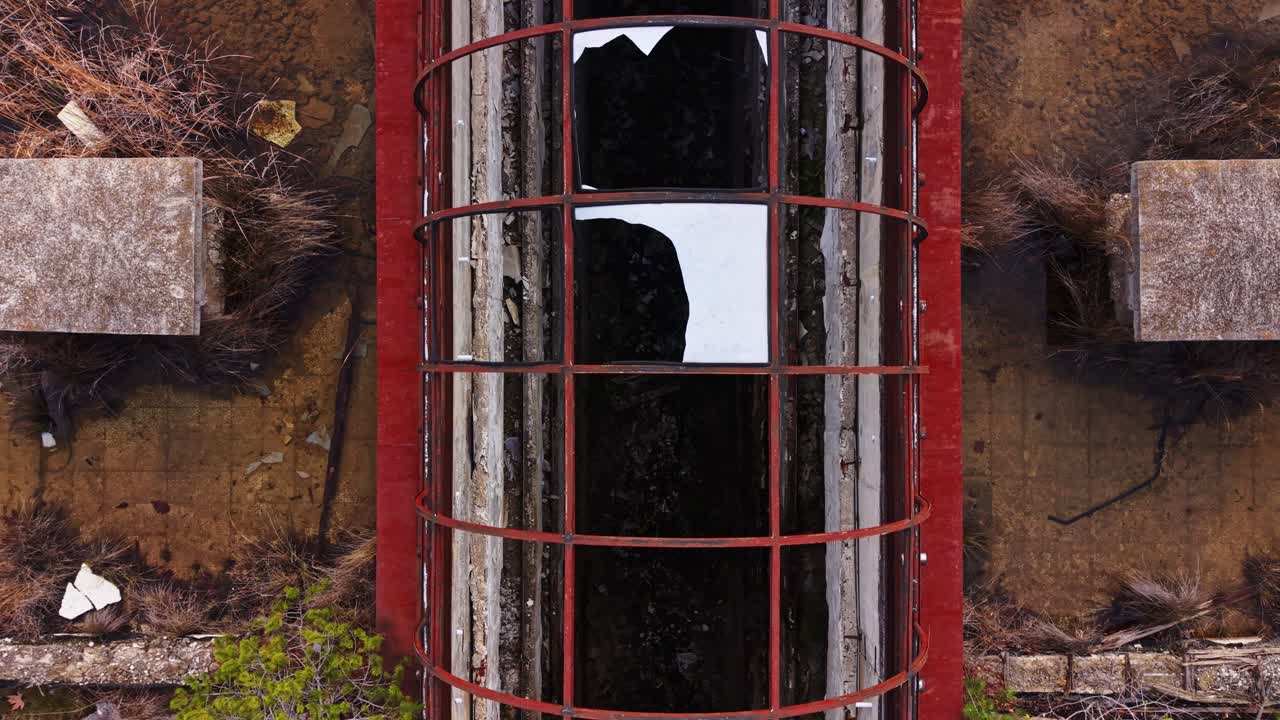Aerial view of abandoned building with broken roof and graffiti