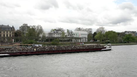 barge ship transports scrap metal and sand with gravel along river main in frankfurt