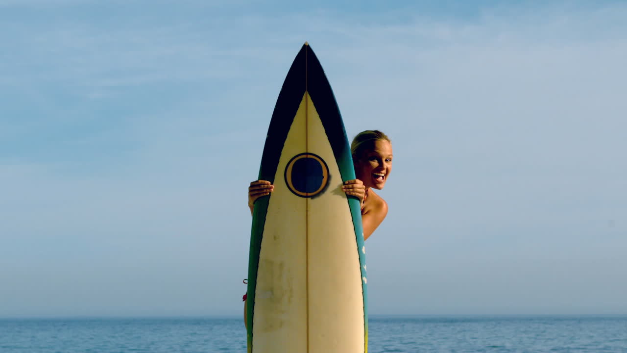 una mujer surfista mirando desde detrás de su tabla