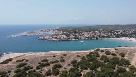 Cinematic-4K-drone-clip-moving-forward-over-the-beach-and-city-of-Anse-du-verdon-with-port-de-Carro-in-background-In-France