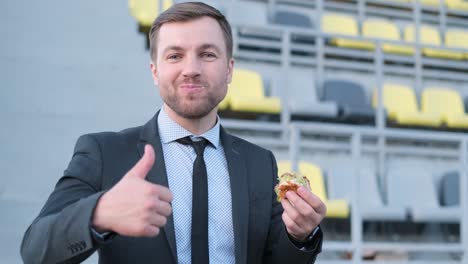 man in suit eating burger