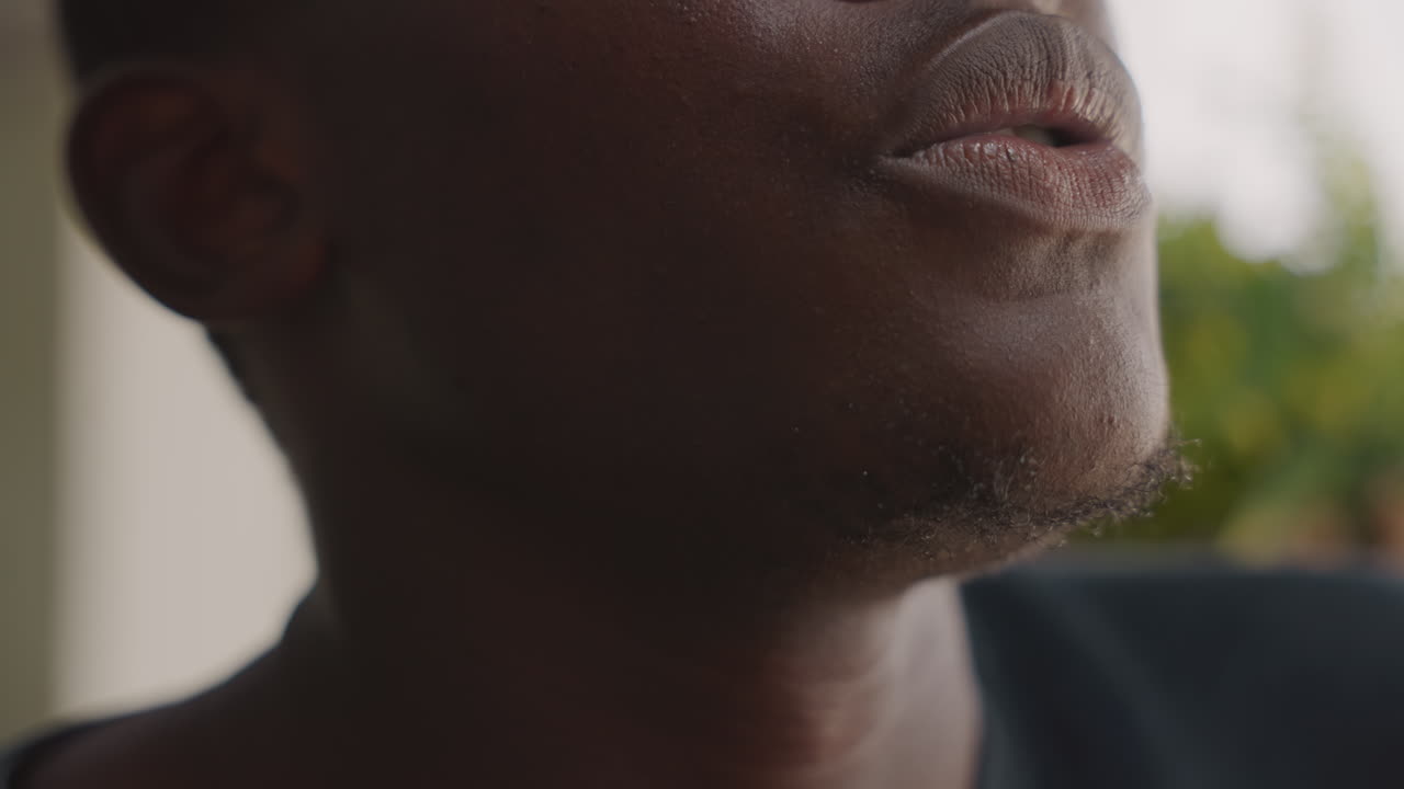 Black man closeup anxious before date, sweaty forehead and lipbiting, thoughtful gaze toward porch, warm sunset light, shallow depth, intimate romantic tension, cinematic portrait mood