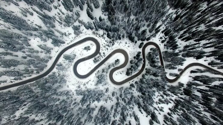 AERIAL: Road in Forest with snow in Dolomites