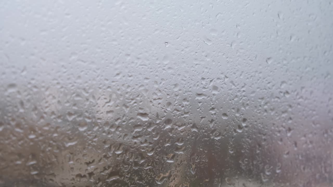 Rain window house. Raindrops trickle down the gray glass.