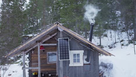 Cabaña-Rústica-De-Madera-Con-Tubo-De-Chimenea-En-La-Montaña-Del-Bosque-Invernal