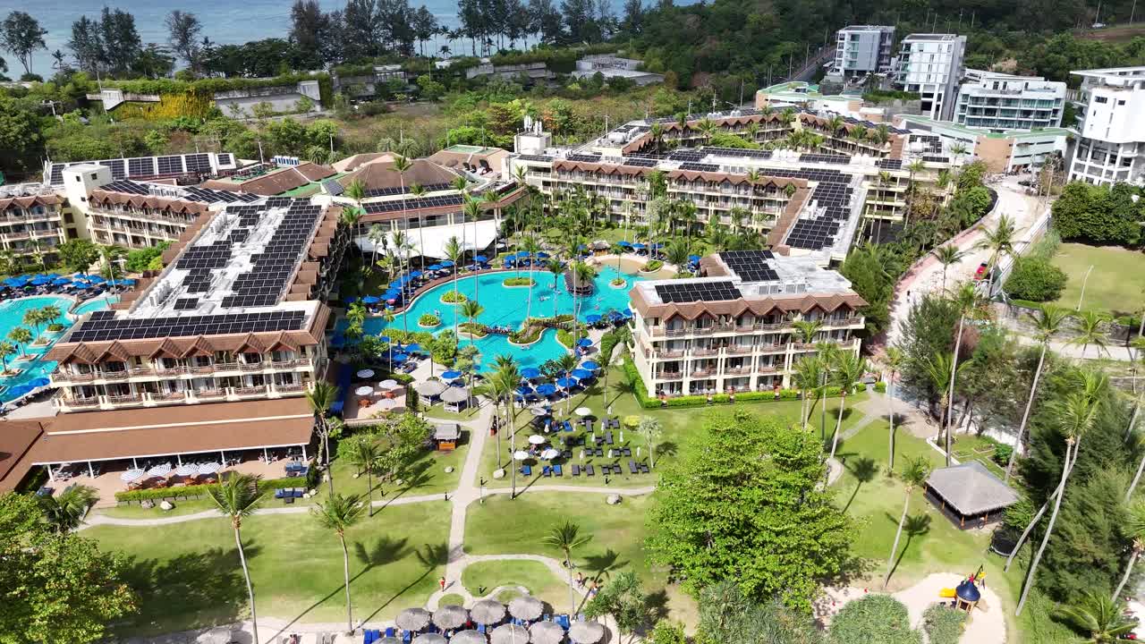 imágenes de drones que muestran un complejo de lujo en phuket, tailandia, destacando piscinas, exuberante vegetación y vistas a la playa bajo la luz del día