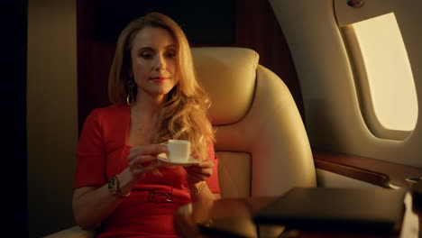 emprendedor cansado descansando en un avión en primer plano. hermosa rubia bebiendo café