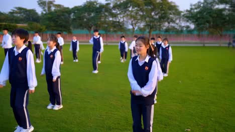 students in uniform performing an exercise in schoolyard