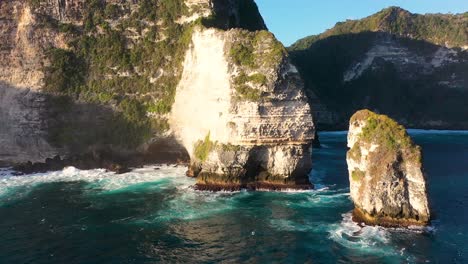 Vista-Aérea-De-Las-Olas-Del-Océano-Turquesa-Rompiendo-La-Costa-De-La-Isla-De-Nusa-Penida,-Una-De-Las-Atracciones-Turísticas-De-La-Isla-De-Bali-Playa-De-Cristal-Playa-De-Kelingking-ángulo-Playa-Rota-De-Billabong