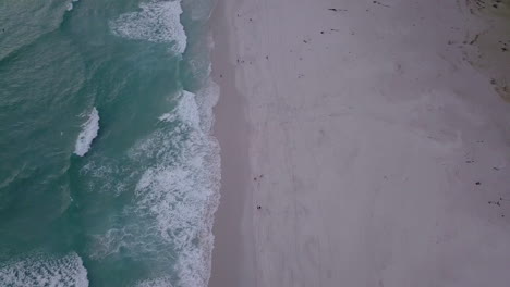 imágenes aéreas de playa y olas y montañas en sudáfrica, ciudad del cabo, noordhoek