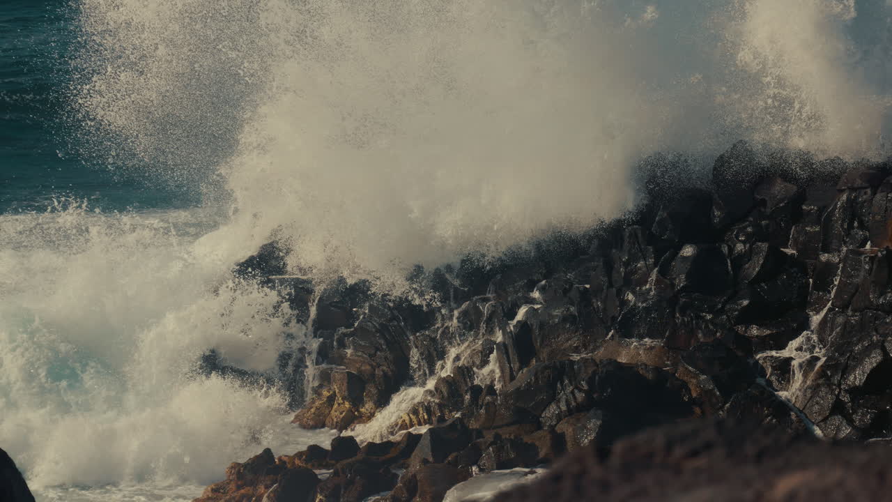 강한 파도가 바위 위에 부히고