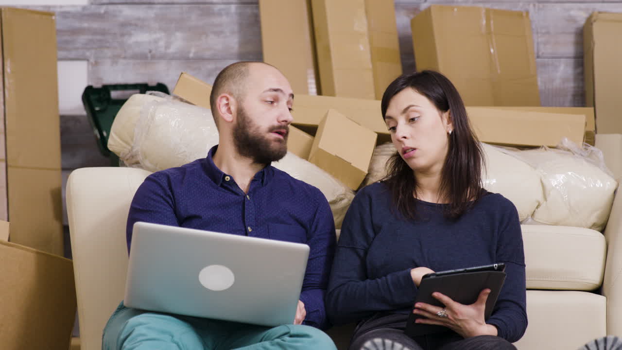 Couple Moving into New Home with Laptop and Tablet