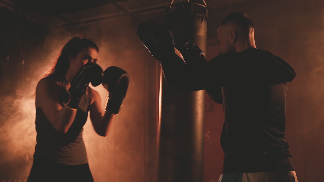 트레이너 장갑을 계속 두드리는 여자 복서 1