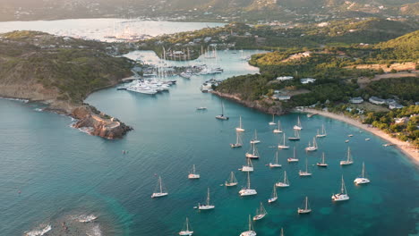 aerial shot of sunset in english harbor in antigua, caribbean with views of yachts, sailboats, marina, bay and cliffs