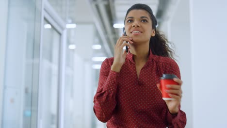 mujer de negocios africana usando teléfono inteligente en el interior