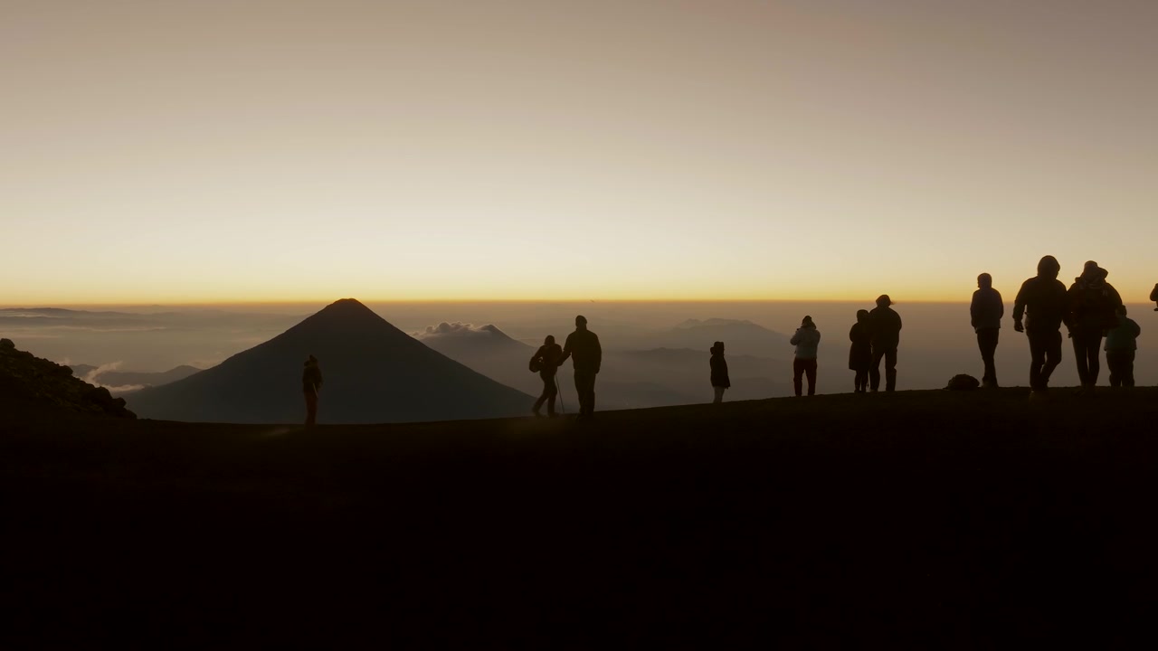 Veduta aerea di escursionisti sulla cima del vulcano Acatenango all'alba, con il vulcano Agua in lontananza in Guatemala. Statico.