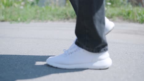 young man walking with guitar on street near forest