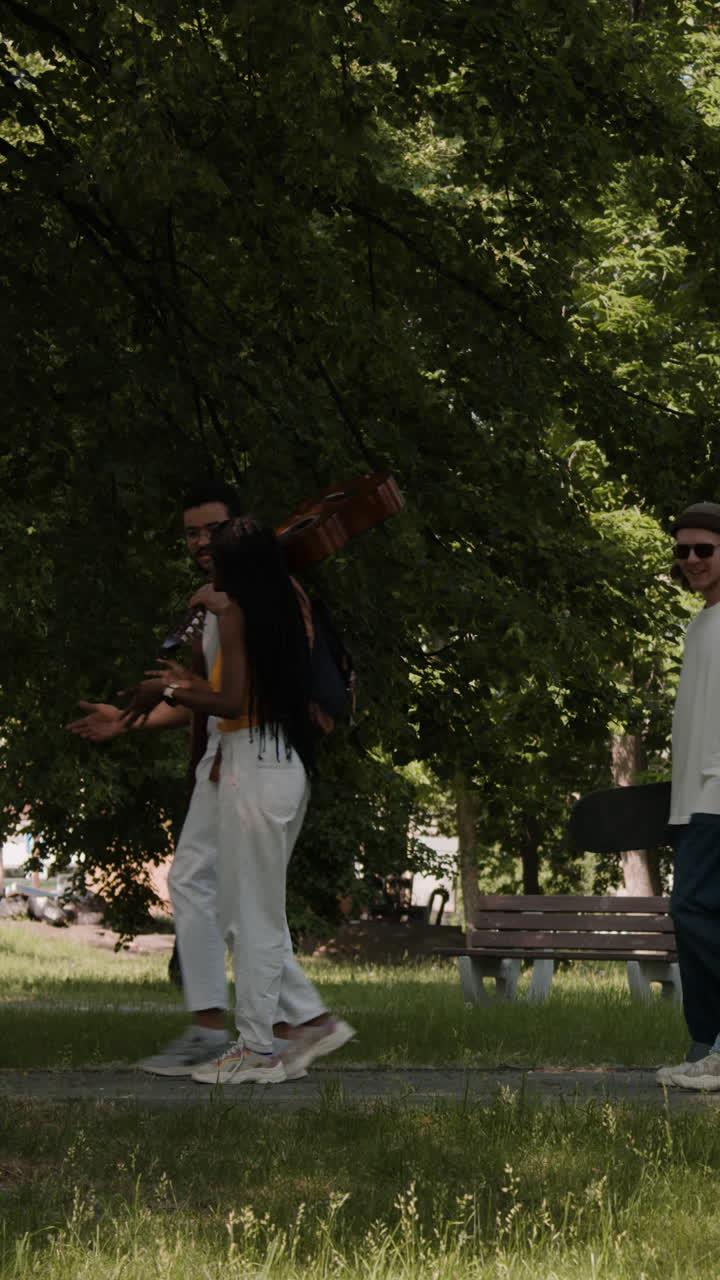 People strolling in a park with a guitar