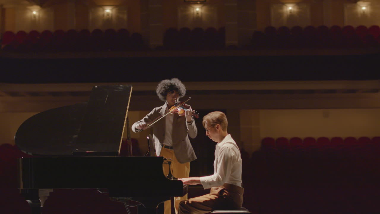 Pianist and Violinist Performing on Music Hall Stage