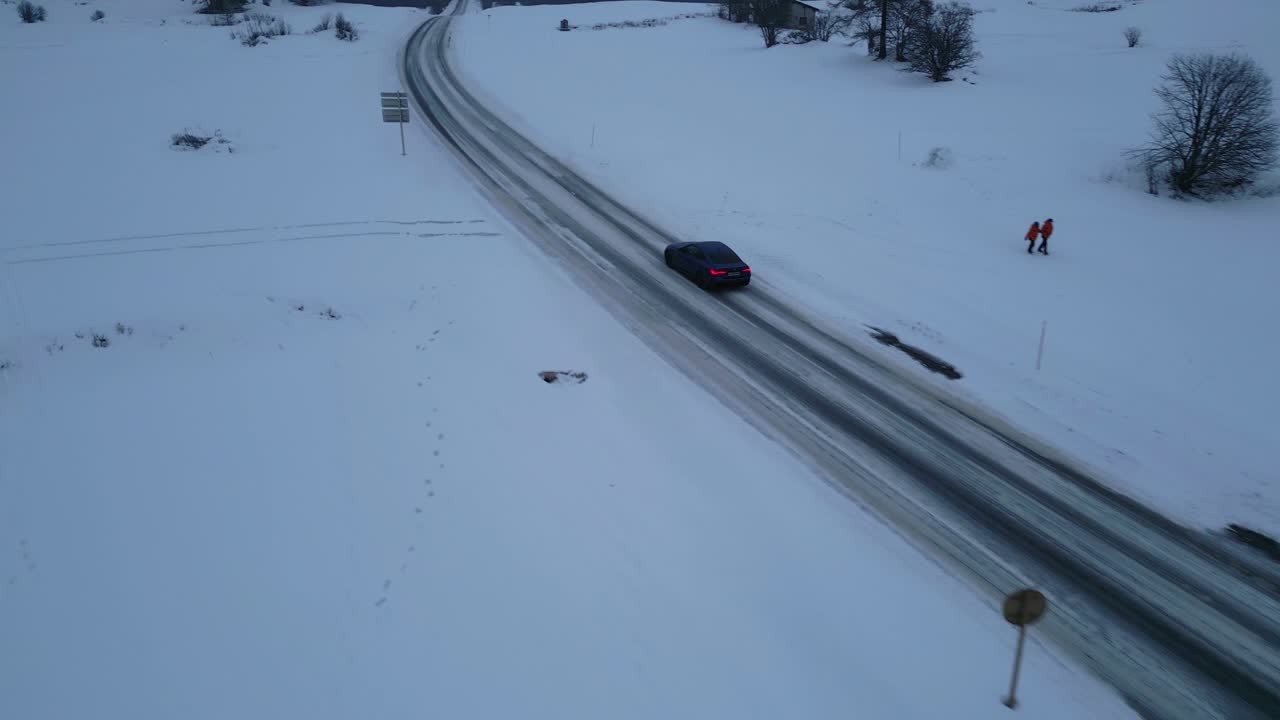 눈이 내리는 긴 도로 위의 자동차