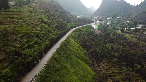 aerial view following the ma pi leng pass uphill towards a rural town