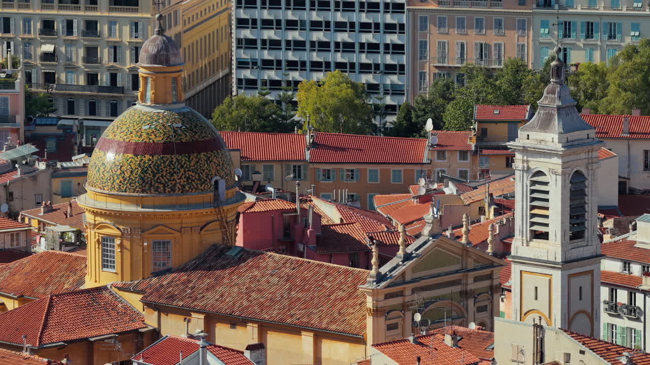 Aerial drone view of Nice Cathedral with its colorful tiled dome, historic bell tower, and surrounding terracotta rooftops of the Old Town