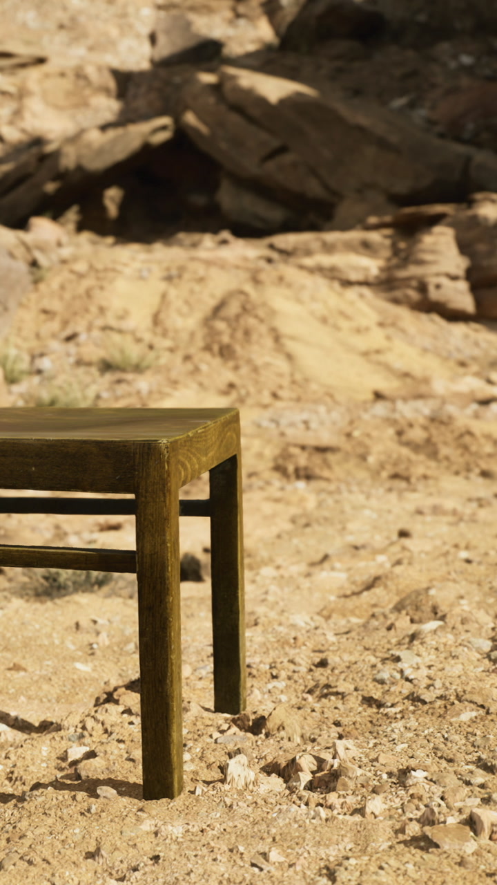 Wooden table stands in a sandy landscape surrounded by rocky formations