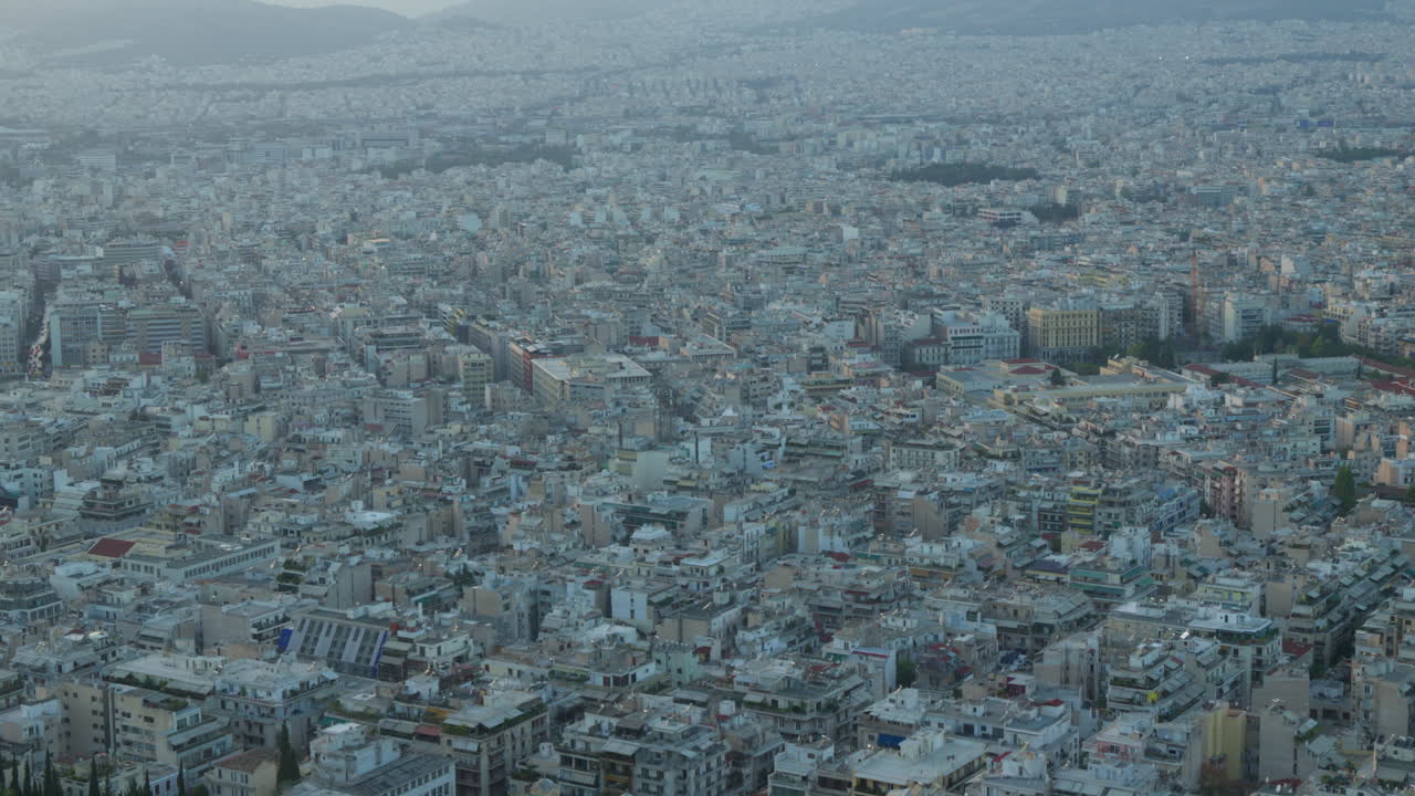 Dense urban sprawl from above, showcasing Athens' cityscape at dusk