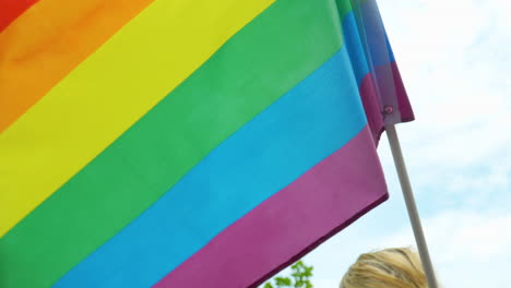 closeup shot of rainbow colored lgbtq+ flag waving in air outdoors