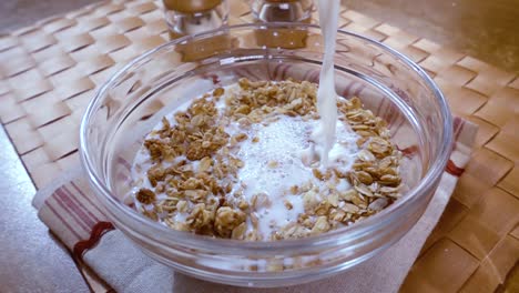 Muesli-De-Cereales-Integrales-En-Un-Tazón-Para-Un-Delicioso-Desayuno-Con-Leche-Por-La-Mañana.-Cámara-Lenta-Con-Seguimiento-De-Rotación.