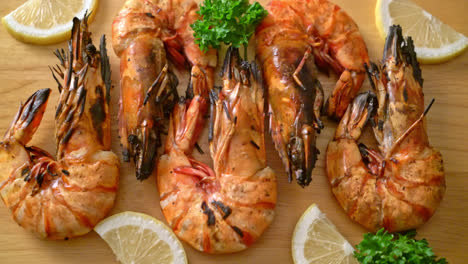 grilled tiger prawns or shrimps with lemon on wood board