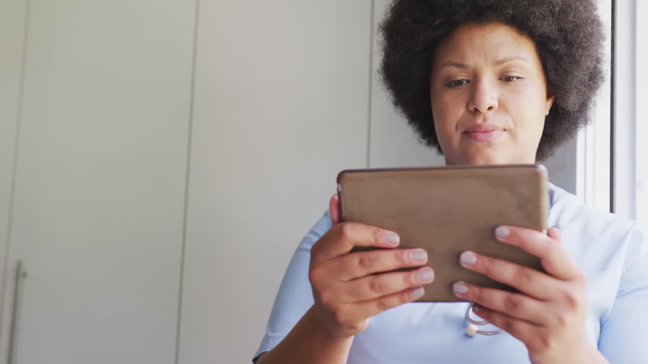 Video of focusedplus size african american female doctor using tablet