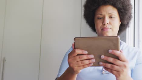 Video-Einer-Fokussierten-Afroamerikanischen-Ärztin-In-Übergröße,-Die-Ein-Tablet-Verwendet