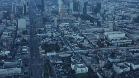 Blue-toned-morning-aerial-panoramic-footage-of-downtown-with-modern-downtown-skyscrapers-and-historic-Palace-of-Culture-and-Science.-Warsaw,-Poland