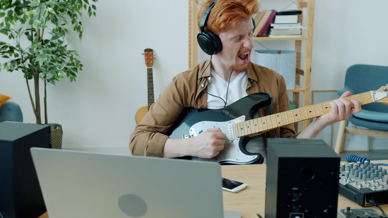 가정 스튜디오에서 전기 기타를 연주하는 남자