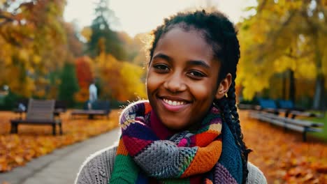 portrait of a smiling young woman in an autumn park