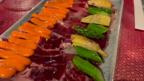 Traditional-Iberico-pork-with-asparagus,-artichoke-and-an-orange-sauce,-classic-Spanish-tapas-starter-in-Marbella-Spain,-4K-shot