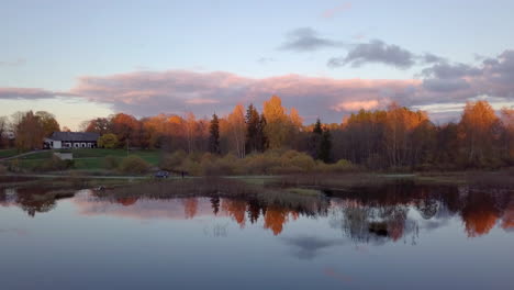 Bei-Sonnenuntergang-Im-Herbst-Vorwärts-über-Den-Teich-Fliegen-Und-Neben-Dem-Auto-Einen-Nicht-Identifizierten-Drohnensitz-Auf-Der-Straße-Enthüllen