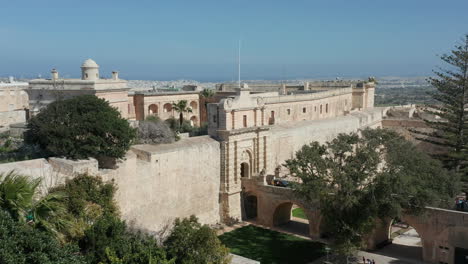 Drone-Shot-of-the-Medieval-City-of-Mdina,-its-Fortification-Walls-and-Main-Gate,-Malta