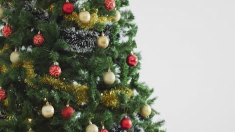 Video-of-christmas-tree-decorated-with-baubles-on-white-background