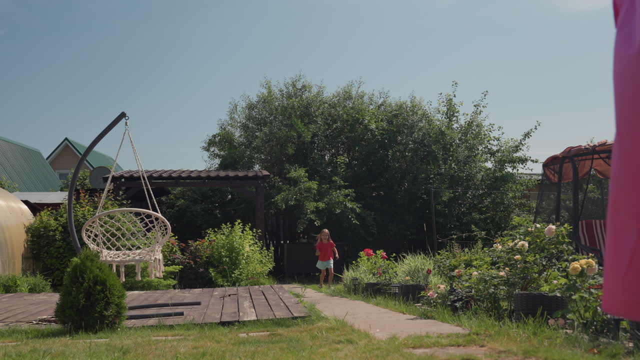Girl And Dog Playfully, Child And Playful Puppy Dash Through Garden On Sunny Day Outdoors, Youthful Girl And Energetic Corgi Race Along Garden Path Amid Summer Scenery And Outdoor Leisure Activities