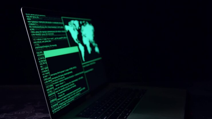 Concetto di hacker. Codice su un monitor di computer portatile in una stanza buia